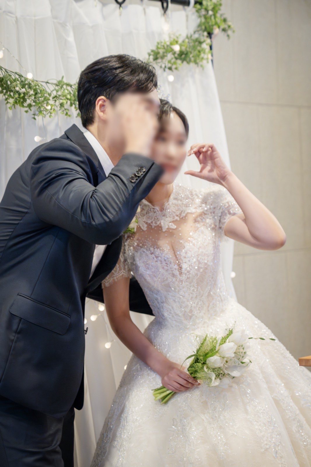 포토부스 앞에서 포즈를 취한 신랑신부